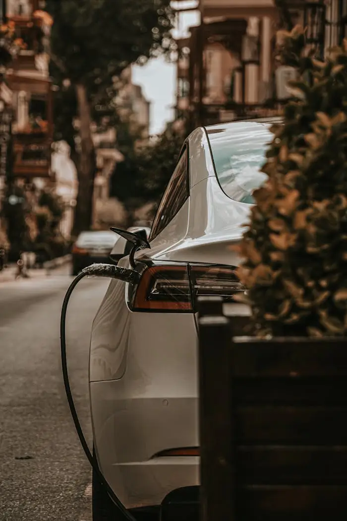 White electric car charging on an urban city street, emphasizing eco-friendly transportation.