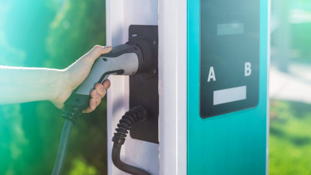 homme debranchant le chargeur electrique du quai a la station de charge