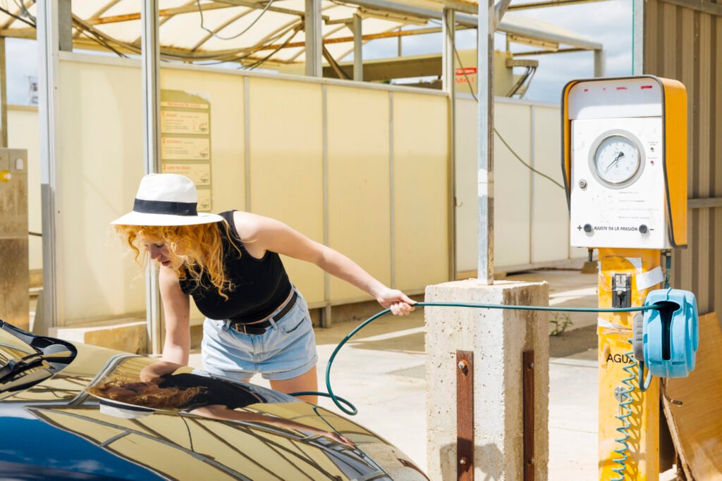 jeune femme pompant des pneus de voiture a la station d essence