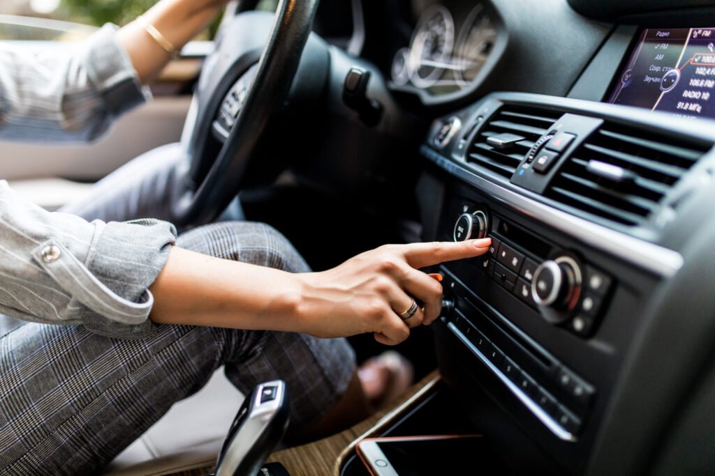 tableau de bord de voiture gros plan de la radio femme met en place la radio en conduisant une voiture 1 1