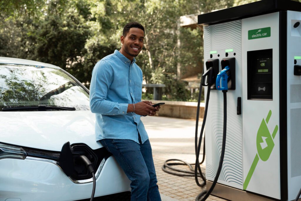 vue laterale smiley homme attendant que la voiture se recharge 2