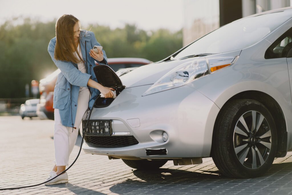 femme charger electro voiture electrique essence station